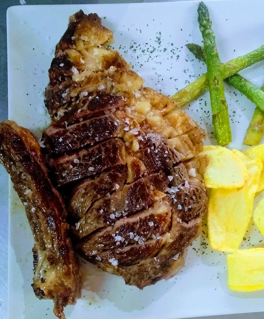 Chuletón de ternera a la parrilla con espárragos trigueros y patatas fritas