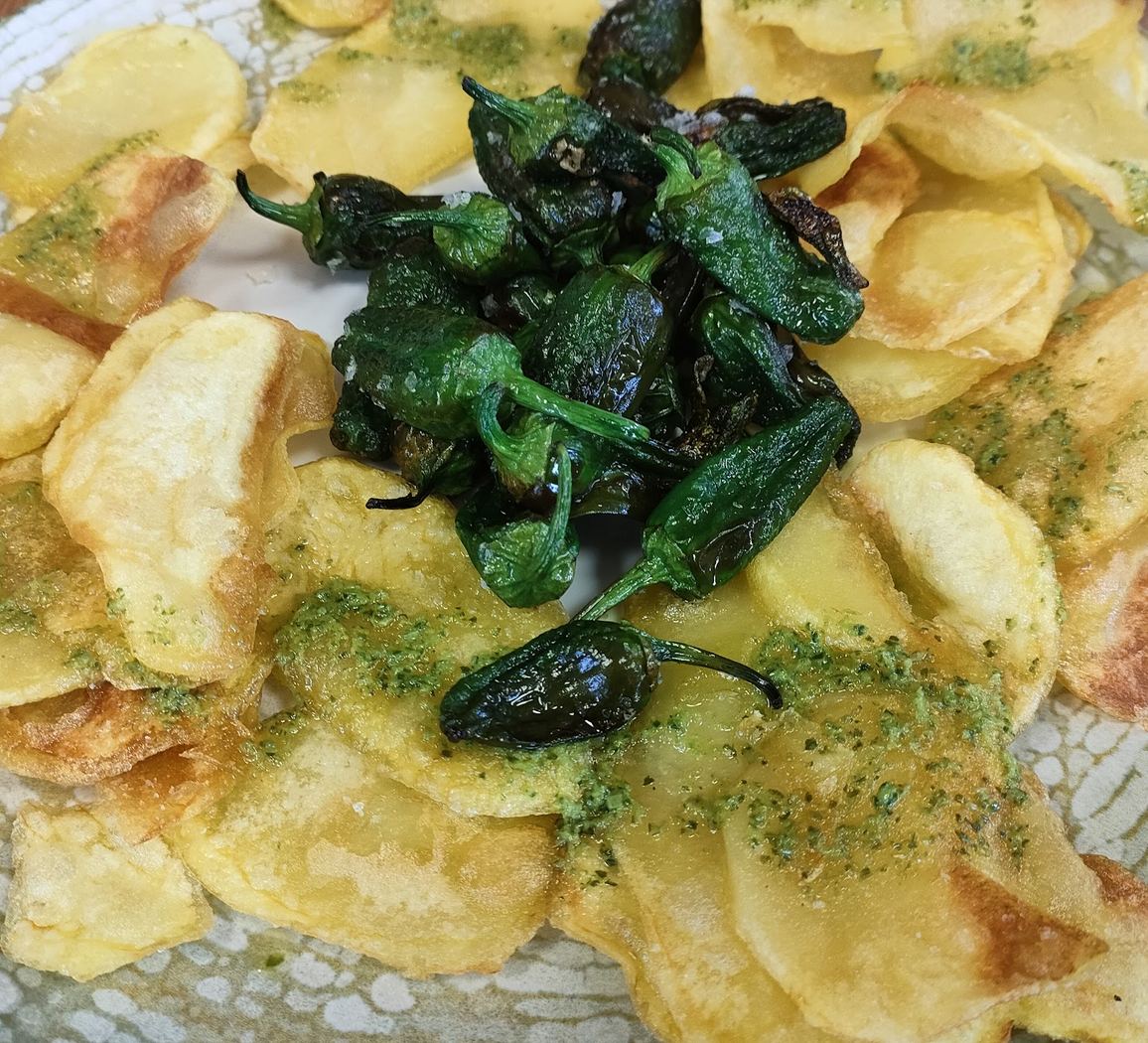 Pimientos de Padrón fritos servidos con patatas fritas caseras